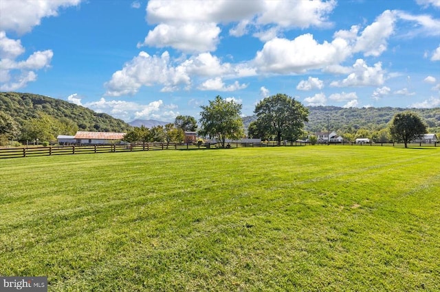 view of yard with a mountain view and a rural view