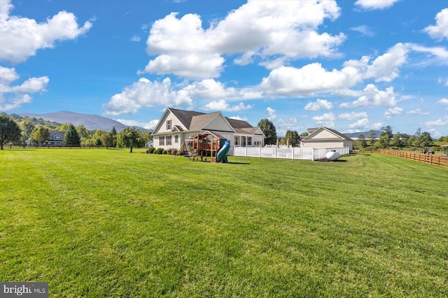 view of yard with a playground, a mountain view, and a rural view