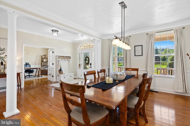 dining area featuring ornamental molding, hardwood / wood-style floors, and decorative columns