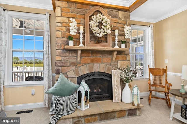 carpeted living room featuring a wealth of natural light, crown molding, and a fireplace