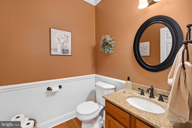 bathroom with vanity, toilet, and hardwood / wood-style flooring