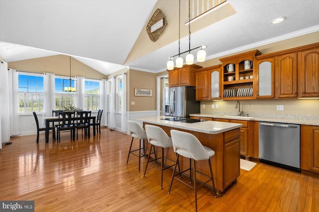 kitchen featuring a center island, hanging light fixtures, appliances with stainless steel finishes, and light hardwood / wood-style floors