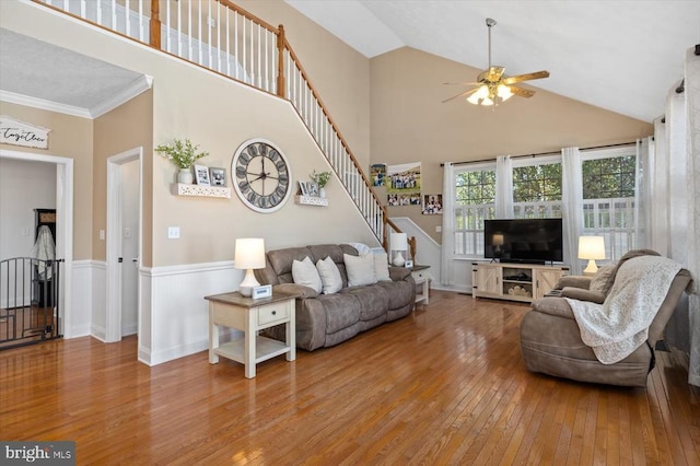 living room featuring high vaulted ceiling, wood-type flooring, ornamental molding, and ceiling fan