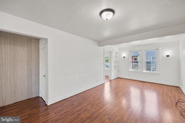 unfurnished room featuring dark wood-type flooring