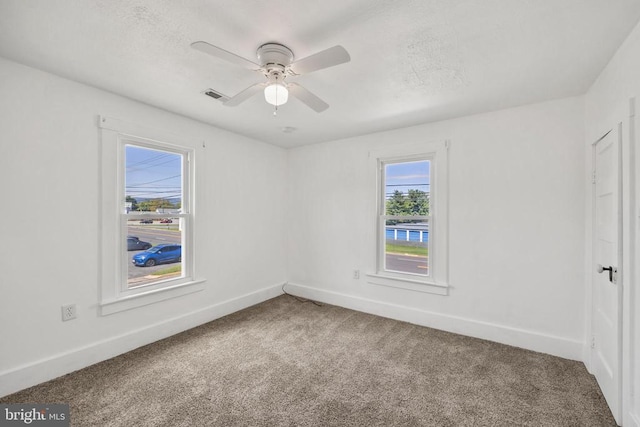 carpeted spare room with ceiling fan