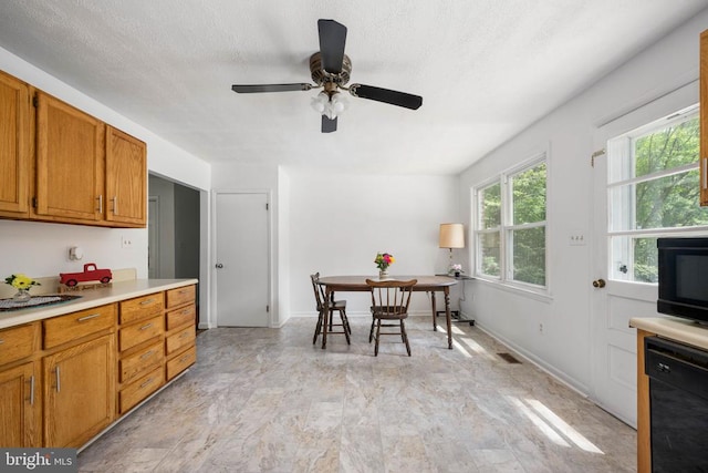 kitchen with ceiling fan, black dishwasher, and a textured ceiling