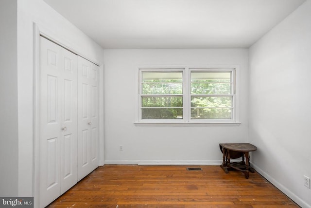 unfurnished bedroom with a closet and wood-type flooring