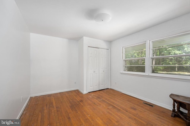 unfurnished bedroom with a closet and hardwood / wood-style flooring