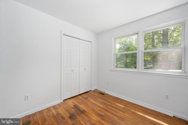 unfurnished bedroom with hardwood / wood-style flooring and a closet