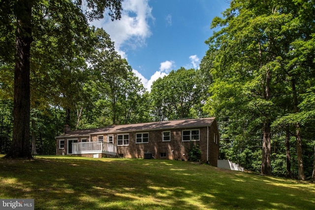 ranch-style house with a wooden deck and a front yard