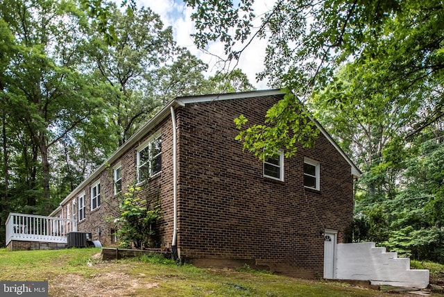 view of side of home with central air condition unit and a wooden deck