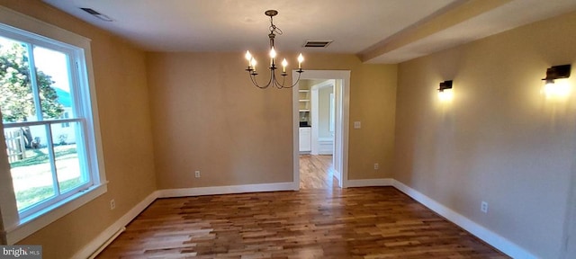 unfurnished dining area featuring hardwood / wood-style flooring and a notable chandelier