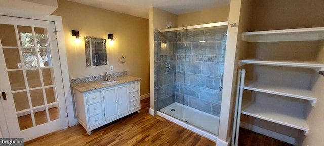 bathroom with a shower with shower door, vanity, and hardwood / wood-style flooring