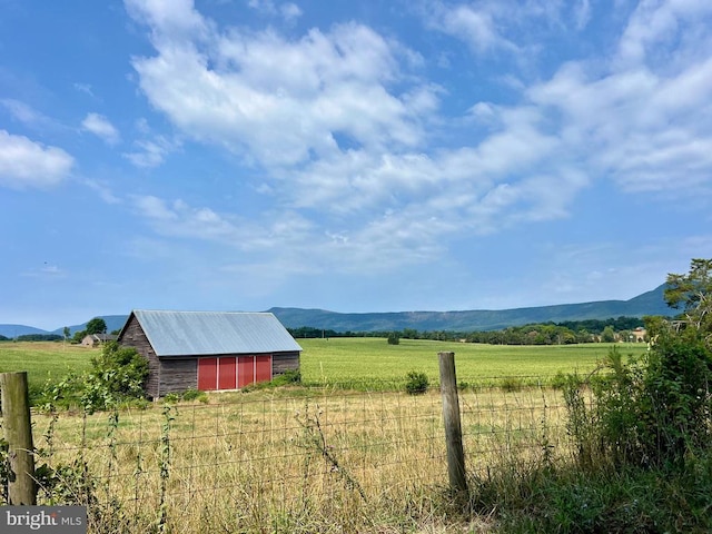 view of yard with a mountain view, a rural view, and an outbuilding