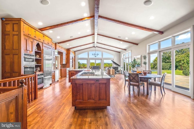 kitchen featuring hardwood / wood-style flooring, lofted ceiling with beams, and a wealth of natural light