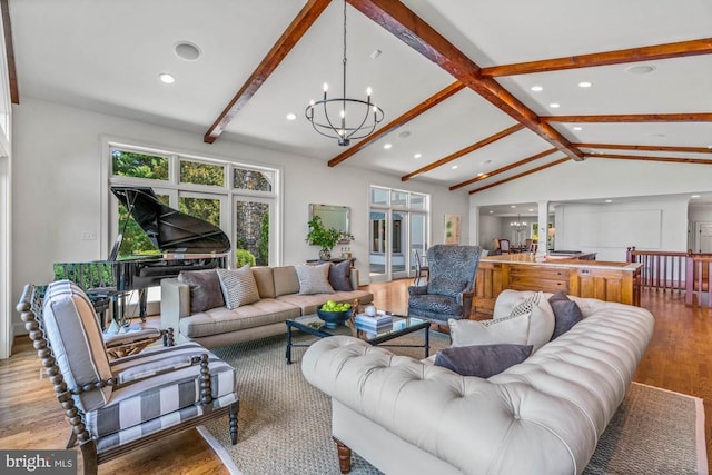 living room with vaulted ceiling with beams, a notable chandelier, and light hardwood / wood-style floors