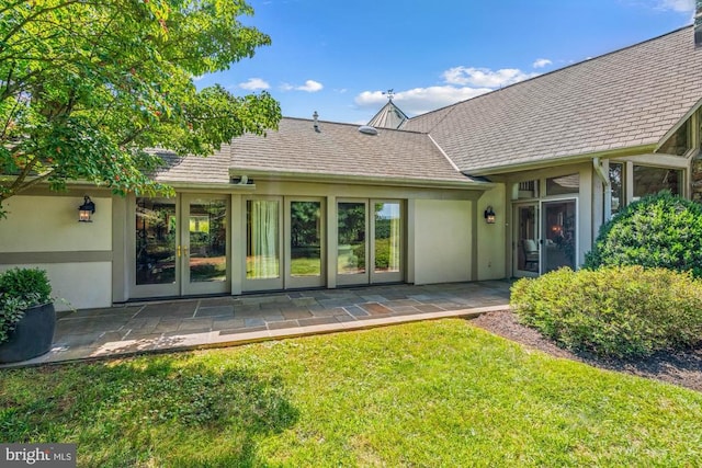 rear view of property with a lawn and a patio