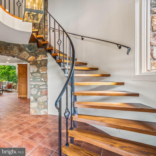 stairway featuring plenty of natural light and tile patterned flooring