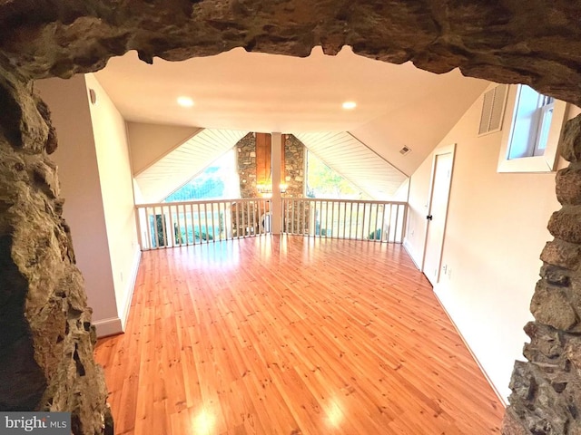 bonus room featuring light wood-type flooring and lofted ceiling