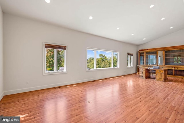 unfurnished living room featuring light hardwood / wood-style flooring, a wealth of natural light, and lofted ceiling