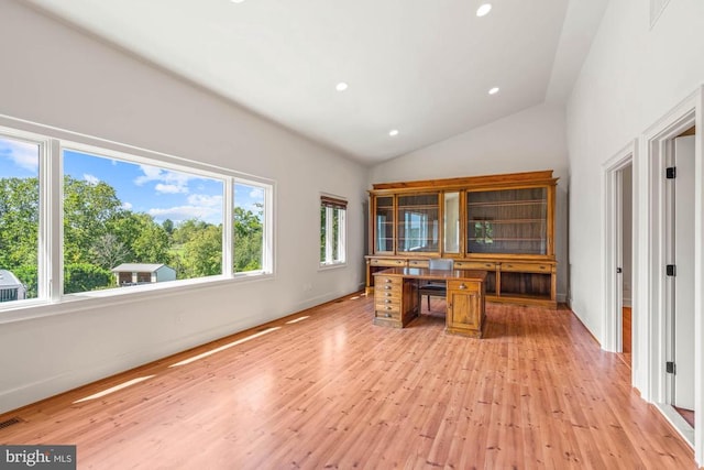 unfurnished office featuring vaulted ceiling and light hardwood / wood-style floors