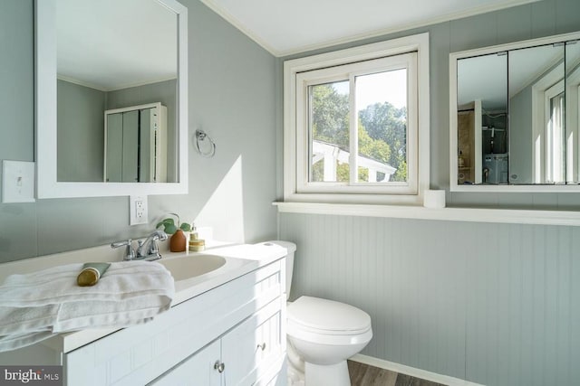 bathroom featuring ornamental molding, wood-type flooring, vanity, and toilet