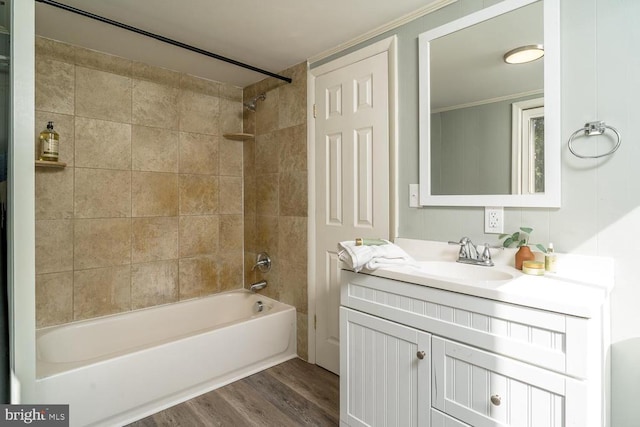 bathroom featuring ornamental molding, tiled shower / bath, hardwood / wood-style flooring, and vanity