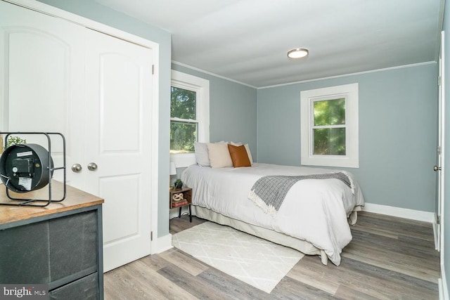 bedroom with wood-type flooring and ornamental molding