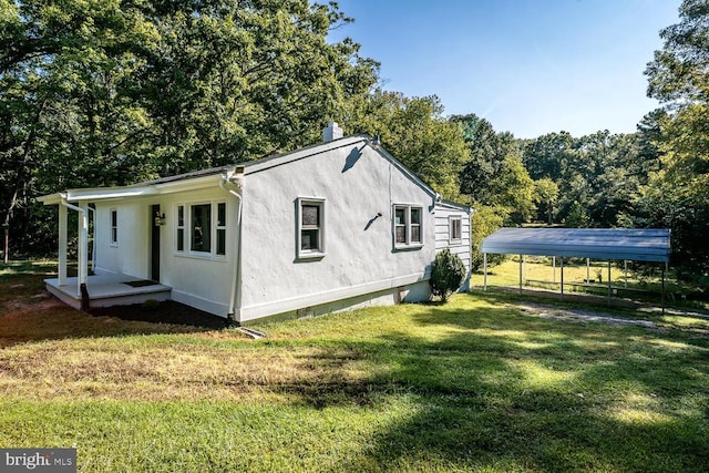 view of side of home with a carport and a yard