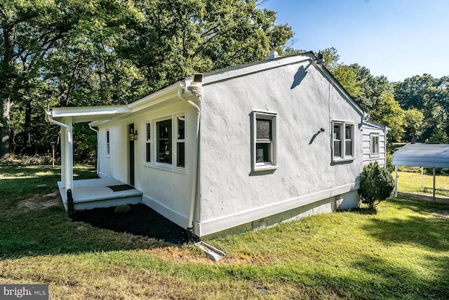 view of home's exterior featuring a lawn and a carport