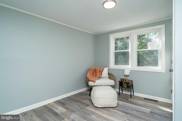 sitting room with hardwood / wood-style flooring and crown molding