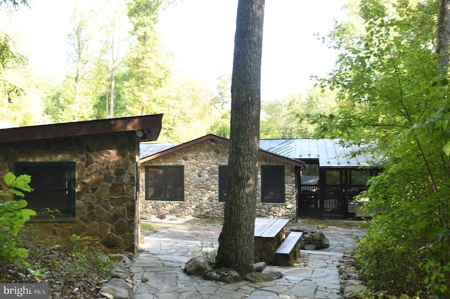 rear view of property featuring a wooden deck and a patio area