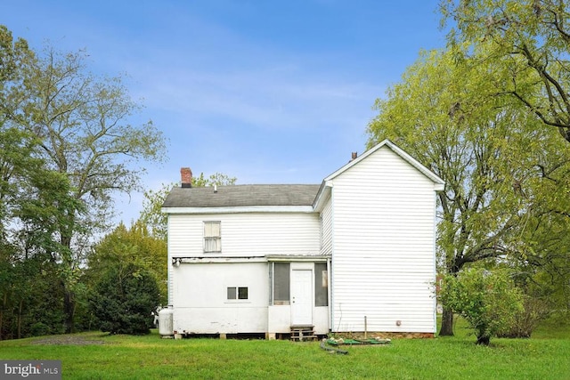 rear view of house featuring a lawn