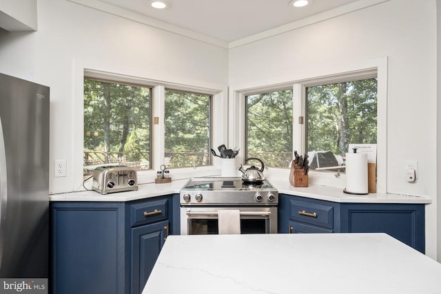 kitchen featuring blue cabinetry, appliances with stainless steel finishes, and ornamental molding