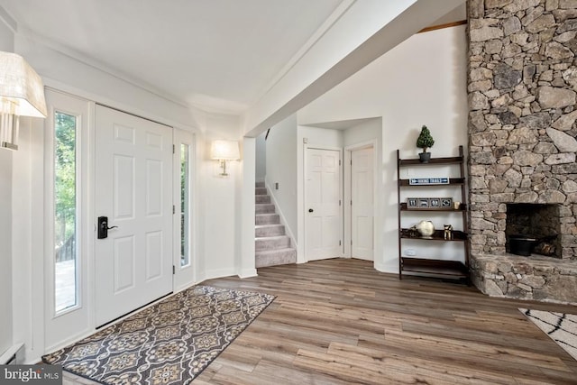 entryway featuring a stone fireplace and hardwood / wood-style flooring