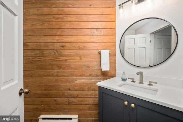 bathroom featuring wooden walls and vanity