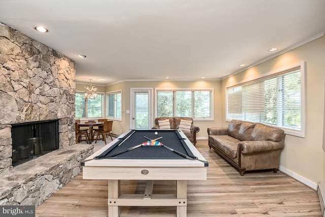 recreation room featuring a stone fireplace, billiards, light wood-type flooring, and crown molding