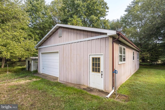 garage featuring a yard and wood walls