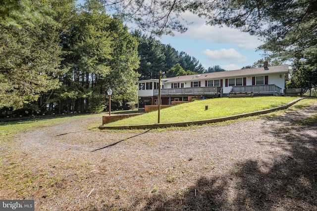 view of front of home with a front lawn and a wooden deck