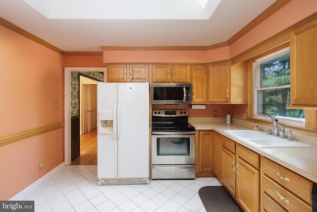 kitchen with a skylight, light tile patterned flooring, sink, stainless steel appliances, and crown molding