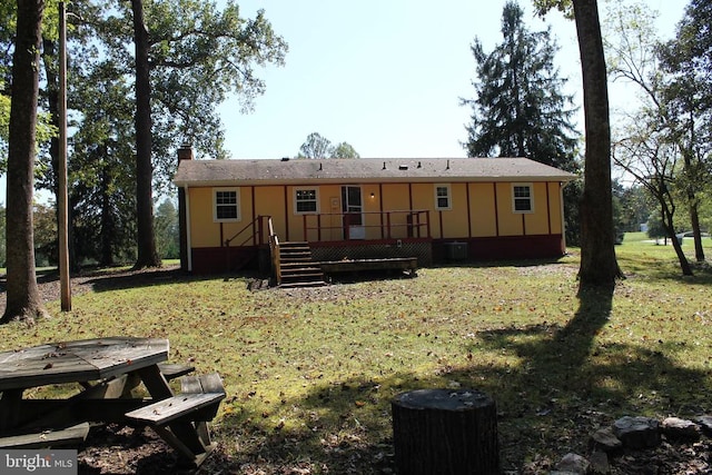 rear view of house featuring a yard