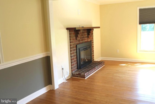 unfurnished living room featuring ornamental molding, wood-type flooring, and a fireplace