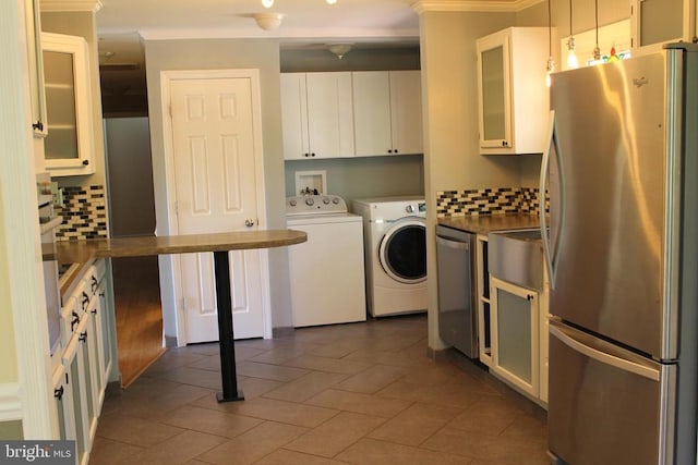 laundry room featuring separate washer and dryer, dark tile patterned flooring, and sink