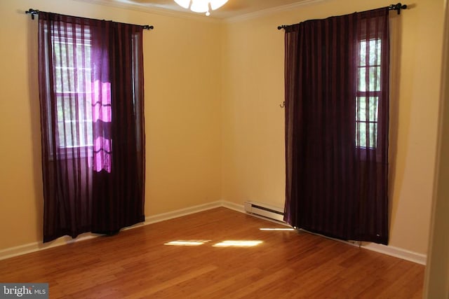 empty room with ornamental molding, ceiling fan, a baseboard heating unit, and hardwood / wood-style flooring