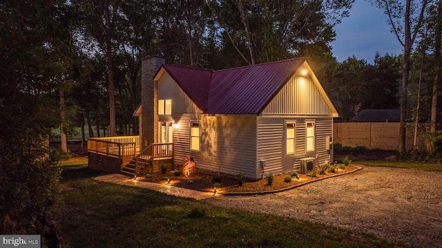 view of home's exterior with central AC, a lawn, and a wooden deck