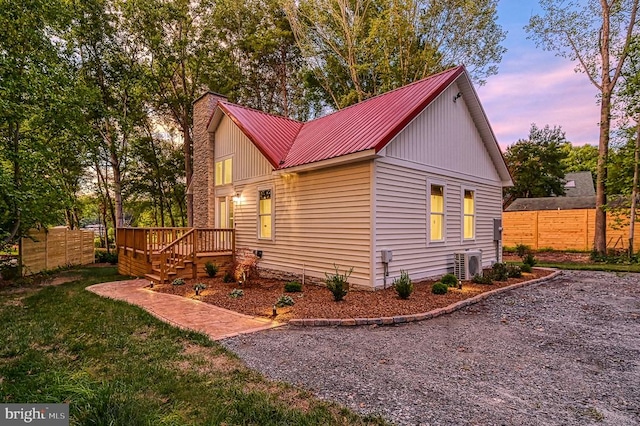 property exterior at dusk featuring a yard and a wooden deck