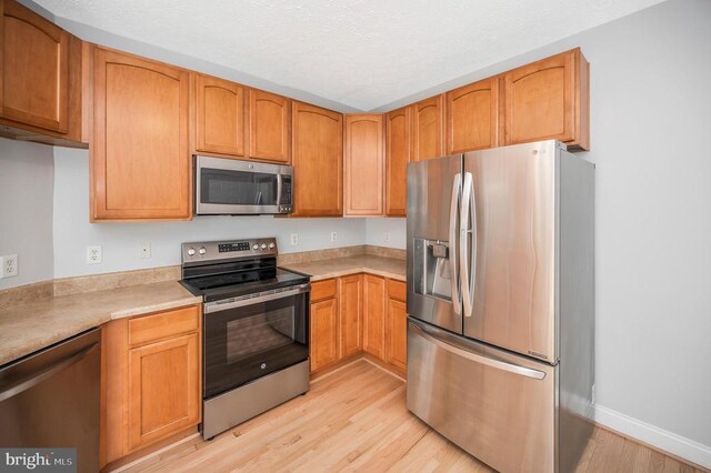 kitchen with stainless steel appliances and light hardwood / wood-style flooring