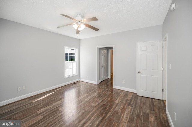 unfurnished bedroom with ceiling fan, a textured ceiling, and dark hardwood / wood-style flooring