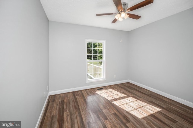 empty room with ceiling fan and dark hardwood / wood-style flooring