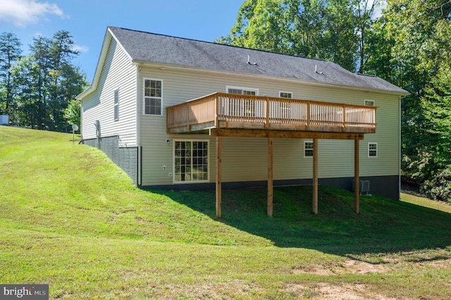 back of property featuring cooling unit, a deck, and a lawn